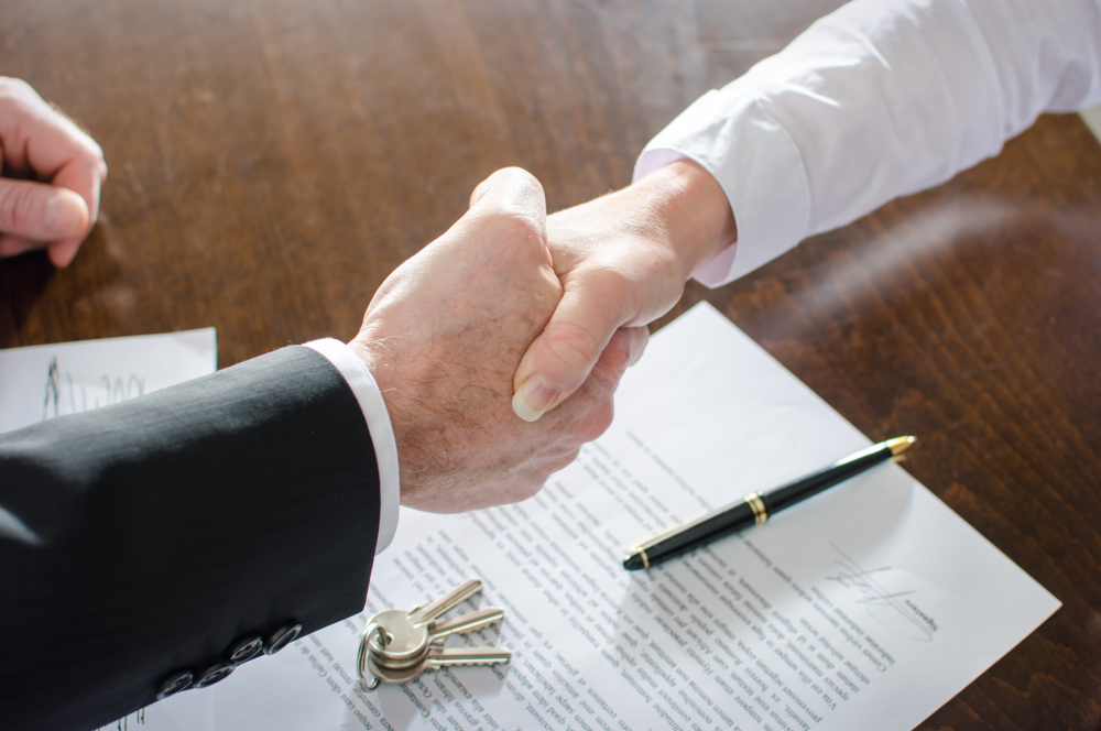 People Shaking Hands After Signing a Contract